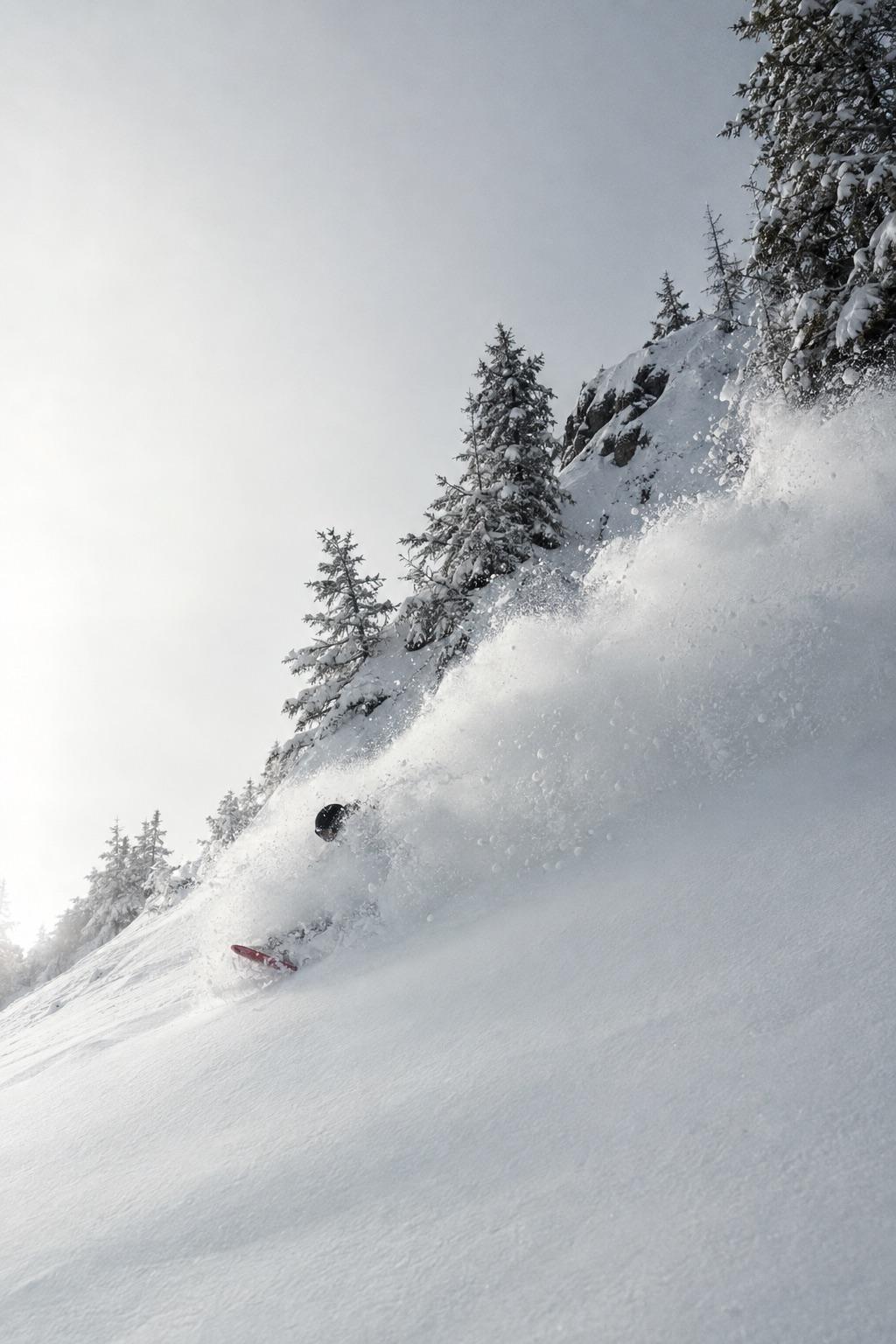 Snowboarder bajando entre nieve polvo